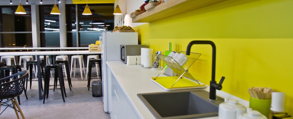 A vibrant yellow wall serves as the backdrop for a sleek counter, creating a bright and inviting atmosphere.