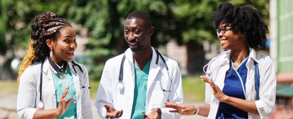 Three doctors engaged in a discussion, sharing insights and collaborating on patient care in a professional setting.