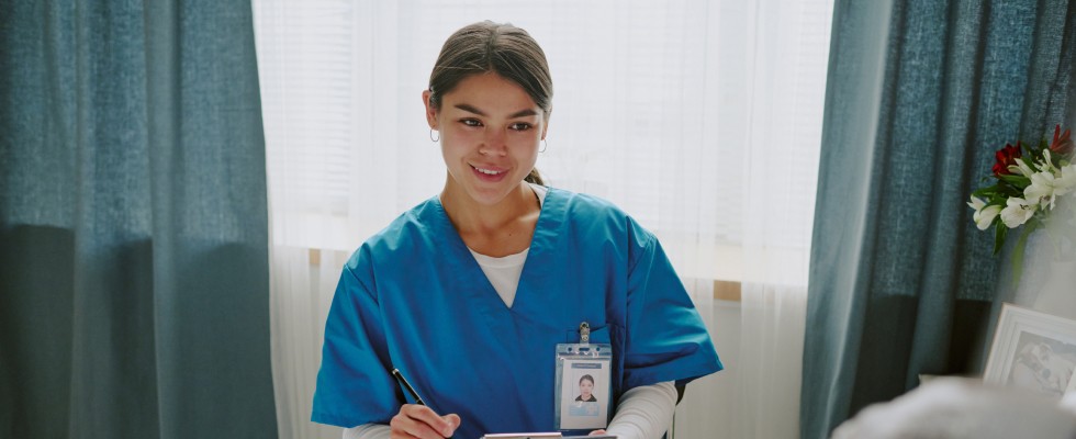 A nurse diligently records patient information on a clipboard in a clinical setting.