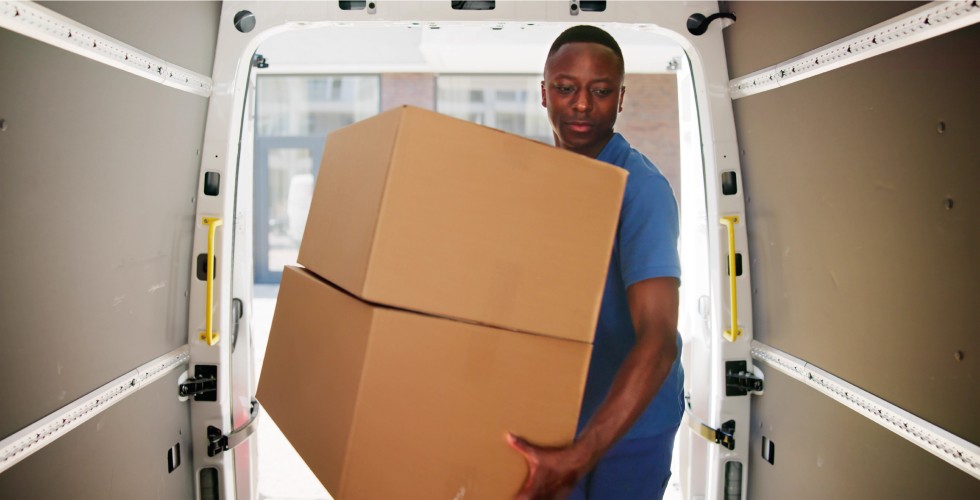 A man carrying a box in a moving van, ensuring safe transportation of goods.