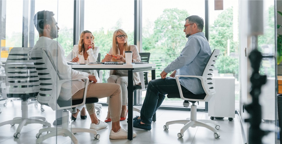 A diverse team of professionals discussing ideas and working together at a conference table in an office setting.