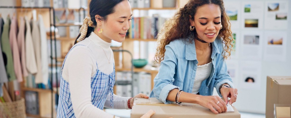 Two women work side by side, focusing on tasks related to inventory management and organization.