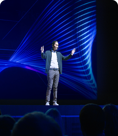 A Sparkathon participant in business attire, holding a microphone and presenting at a Walmart Converge event.