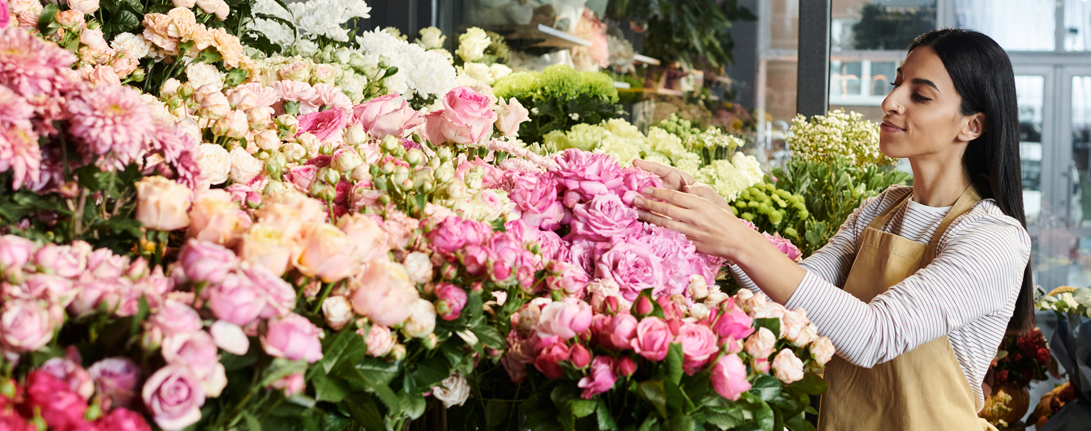 Woman flower shop owner inspecting her inventory.