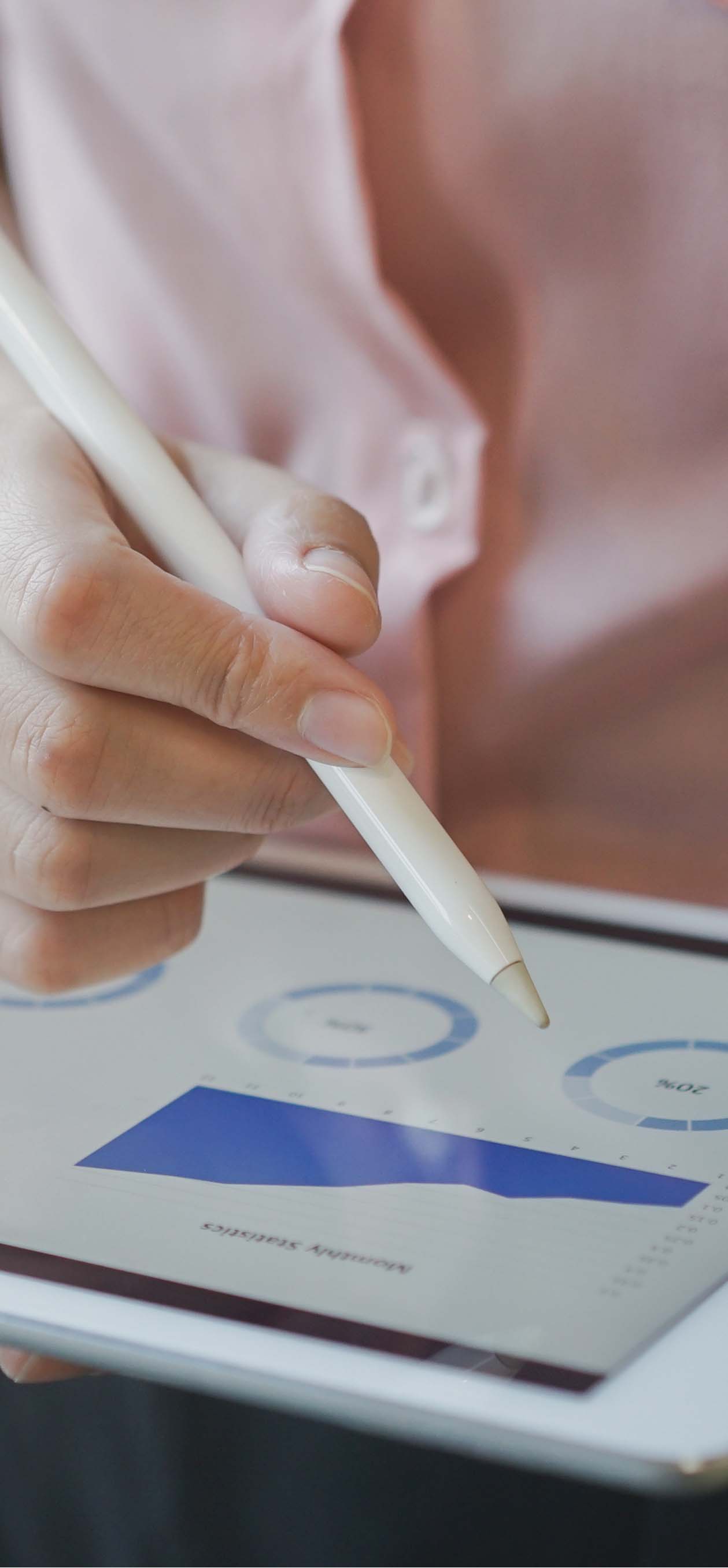 A user uses a tablet pen on a digital tablet device to look at metrics.