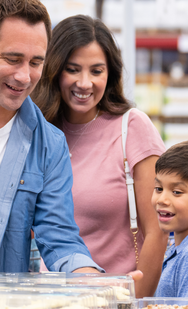 A family examines the shelves of items in a Sam's Club.