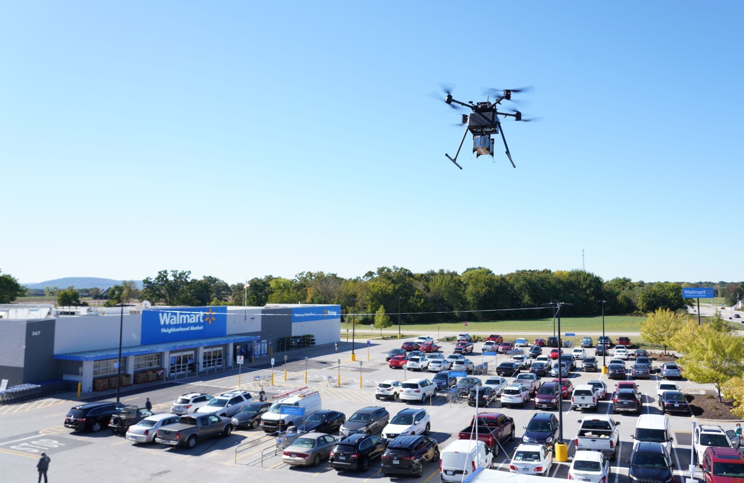 Drone flies through the air over a Walmart parking lot.