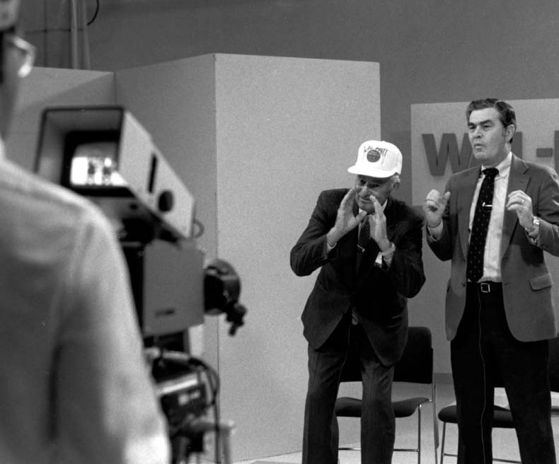 Sam Walton doing the Walmart cheer on a filming set.