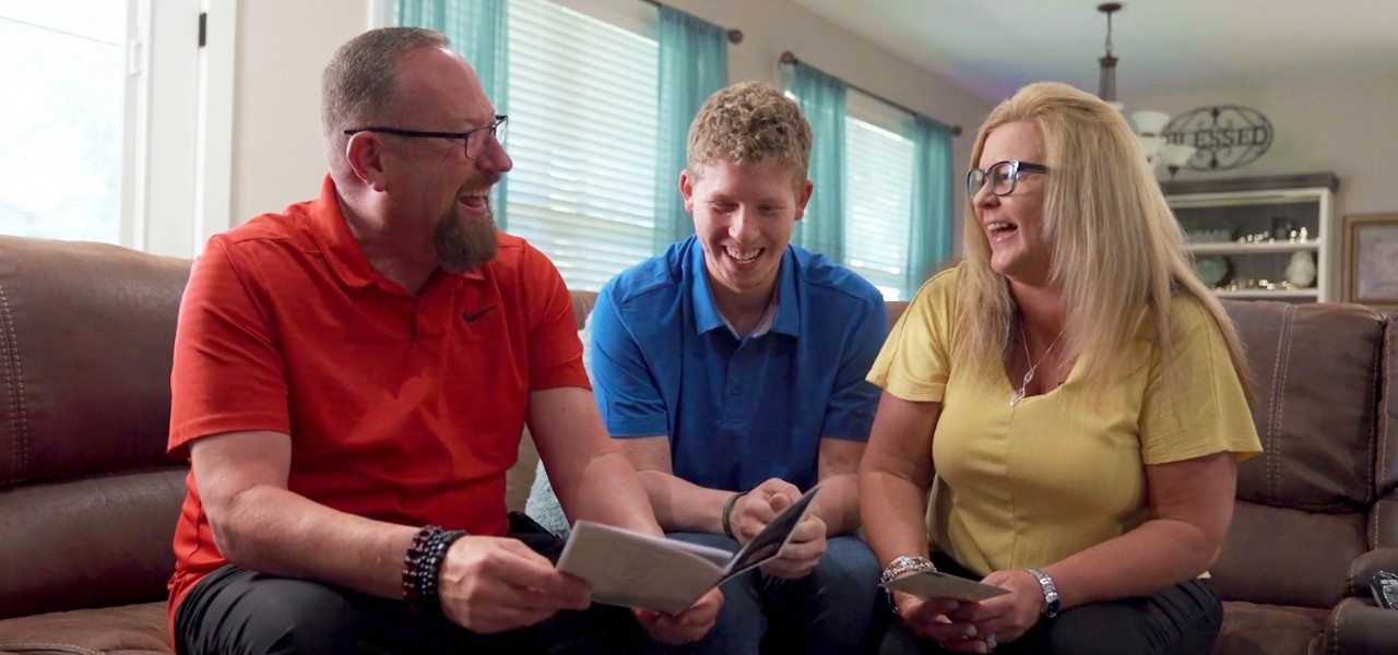 Walmart associates Mark, Conner and Kim Stevens sit together on a couch.