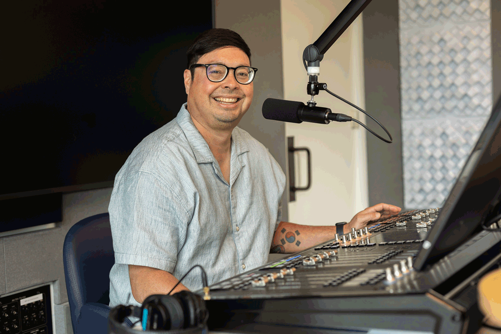 DJ Chris sits at the soundboard in the Walmart Radio studio.